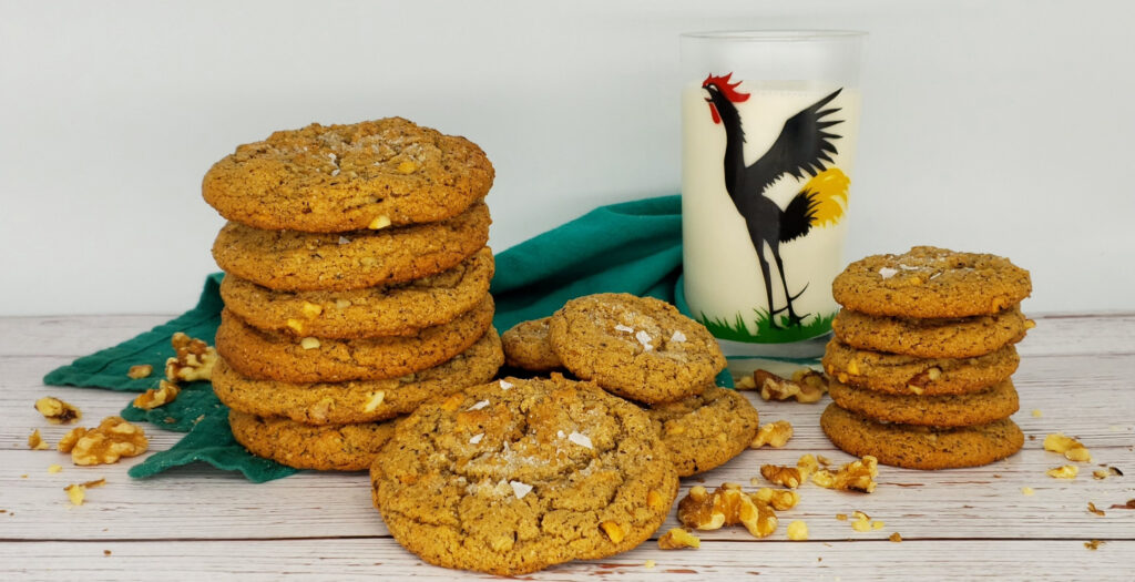 A tall stack of 5-Star Brown Butter Peanut Butter Cookies sits next to a tall glass of cold milk.