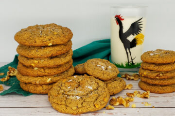 A tall stack of 5-Star Brown Butter Peanut Butter Cookies sits next to a tall glass of cold milk.