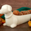 A white porcelain dish shaped like a Dachshund do proudly displays a row of Tempting 2-Bite Sweet Potato Drop Doughnuts.