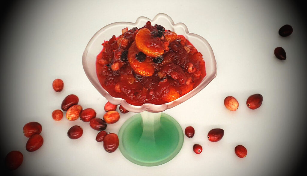 A beautiful serving dish of Easy MOstly Bakes Signature Cranberry Relish boasts slices of mandarin oranges, black currants, nuts, celery and cranberries.