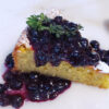 A slice of cake is topped with a generous helping of 20-Minute Thyme Infused Blueberry Sauce.