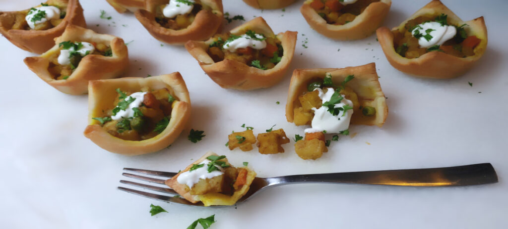 A tray of coconut Curry Puffs shows the versatility of gluten free puff pastry used in this recipe for Easy Ham and Leek Turnovers