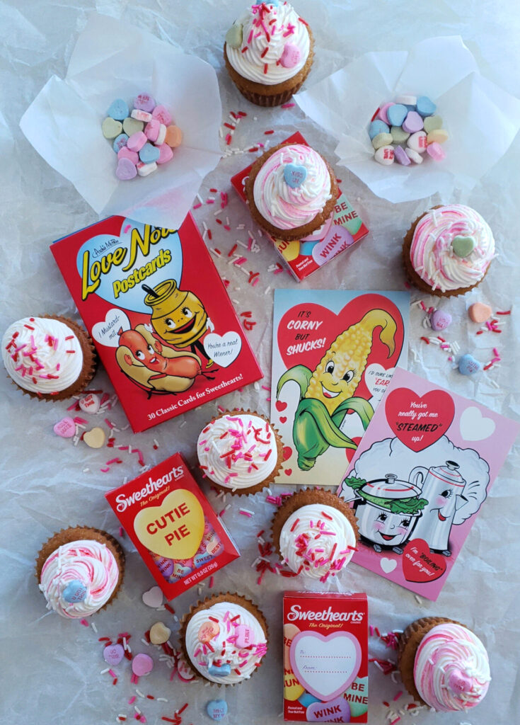 A board of Easy Brown Sugar Love Cupcakes are decorated with vibrant sprinkles and Valentine's Day Heart candies.