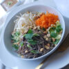 A beautiful bowl of Healthy 4-Element Soba Noodle Salad features fresh napa cabbage, shredded carrots, cilantro, bean sprouts, scallions and peanuts invites you to dig in. A cup of Easy 15-Minute Thai Peanut Coconut Sauce is in the background just waiting to join the salad.