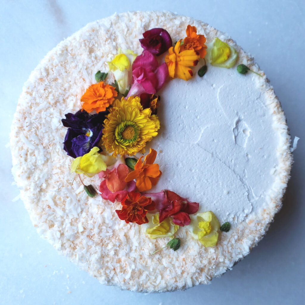 A finished pineapple coconut cake is beautifully iced in 5-Ingredient Easy Basic Buttercream with a hint of Stroh Rum,