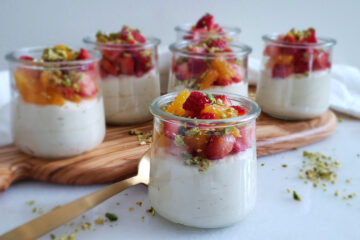 Cups of Heavenly White Chocolate Mousse topped with fresh strawberries, oranges and pistachios sit pretty on a serving tray.