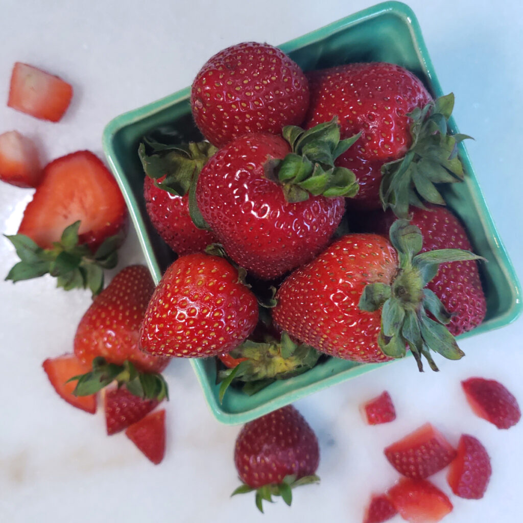 A closeup shot of fresh strawberries used to make this Easy Strawberry Basil Jam in 15 Minutes. 