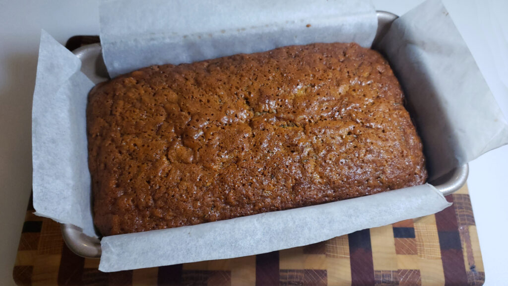 A freshly baked loaf of Best Old Fashioned Zucchini Bread in 60 Minutes sits cooling. Just a few more minutes and it's ready to slice into. 