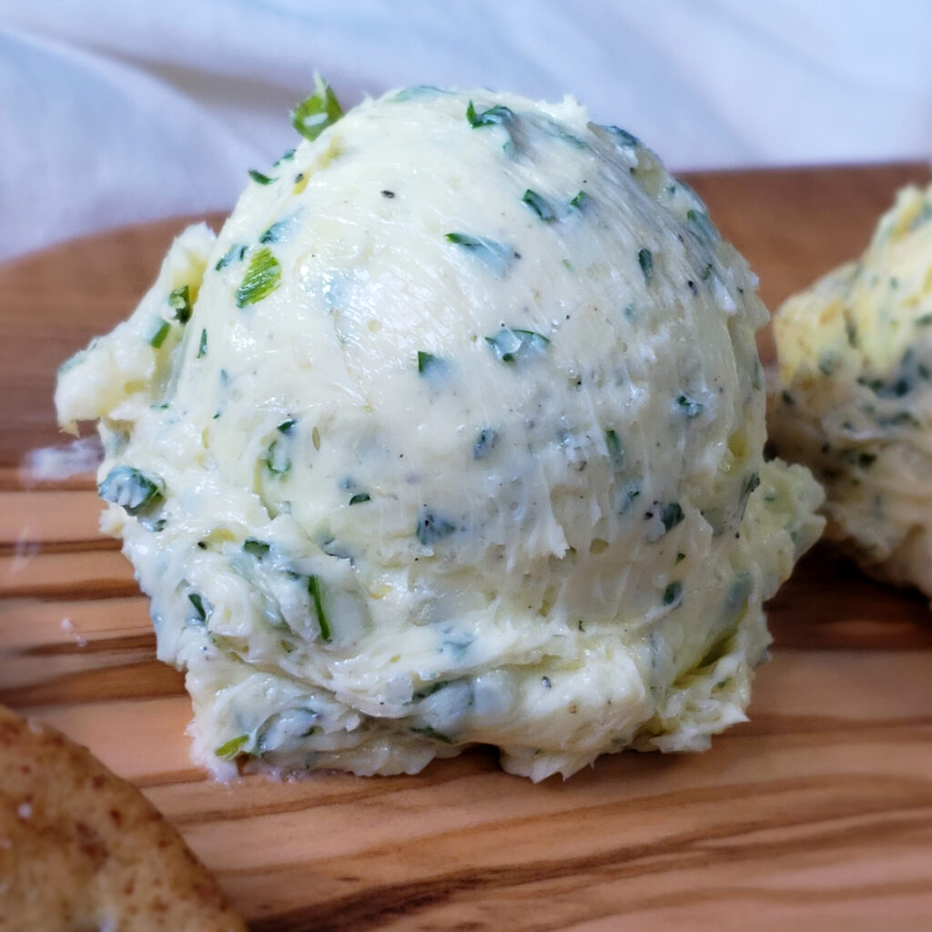 A scoop of the garlic and fresh herb version of this recipe for Easy Sweet and Savory Compound Butter 4 Ways reveals fresh herbs, garlic and a touch of lemon zest to brighten it.