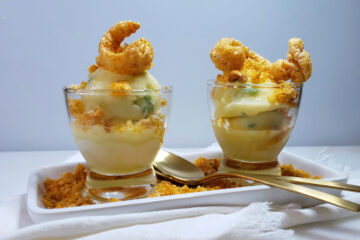 A serving plate with two portions of Easy 5-Ingredient Pineapple Chicharrones Sorbet are topped with crushed chili-flavored cracklings.