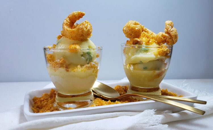 A serving plate with two portions of Easy 5-Ingredient Pineapple Chicharrones Sorbet are topped with crushed chili-flavored cracklings.