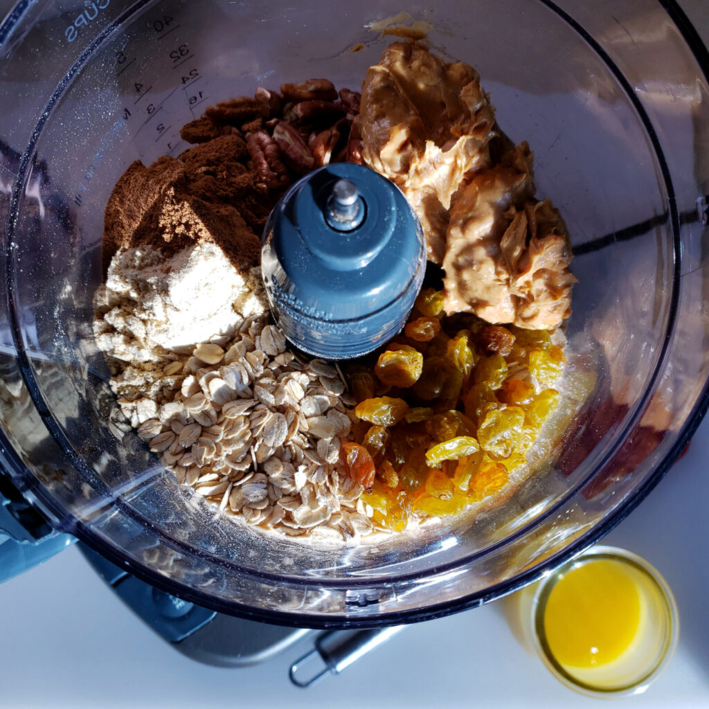 A food processor is filled with all the ingredients needed to make these Easy 7-Ingredient Orange Spice Protein Bites