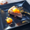 A slice of this Decadent 2 Layer Orange Nutella Cheesecake is topped with fresh oranges and toasted hazelnuts.