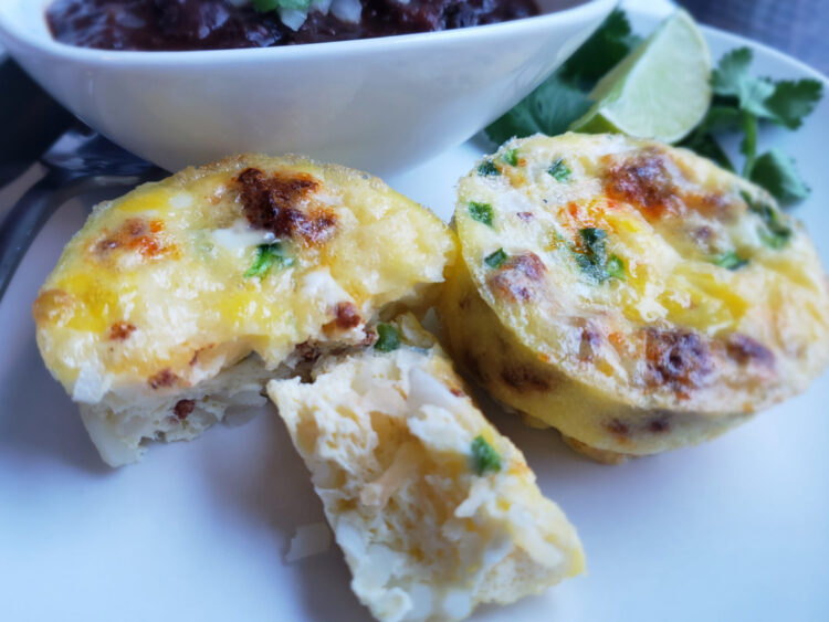 A tray of hot out of the oven Easy Mexican Style Mini Quiche in 30 Minutes. Each quiche has pieces of jalapeno, onion, chorizo and potato suspended in a light, fluffy egg mixture.
