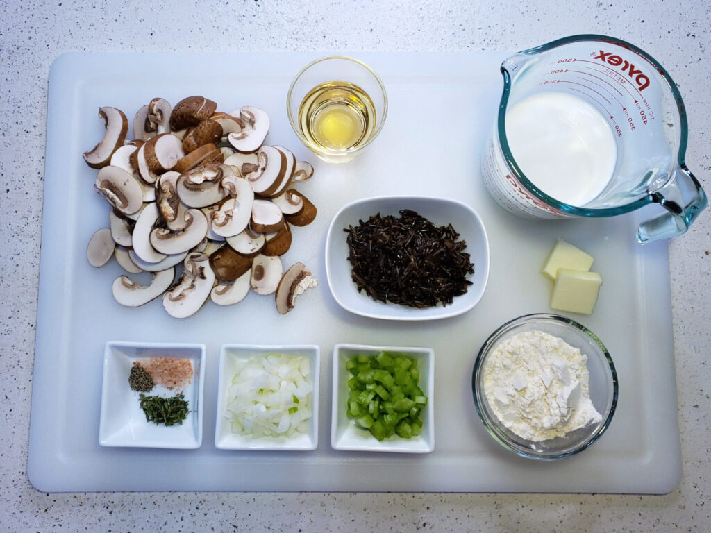 A cutting board features all the ingredients in this Creamy Mushroom and Wild Rice Soup in 60 Minutes.