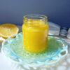 A jar of Quick and Easy 4-Ingredient Lemon Curd sits in the center of a sunbeam - warm and radiant.