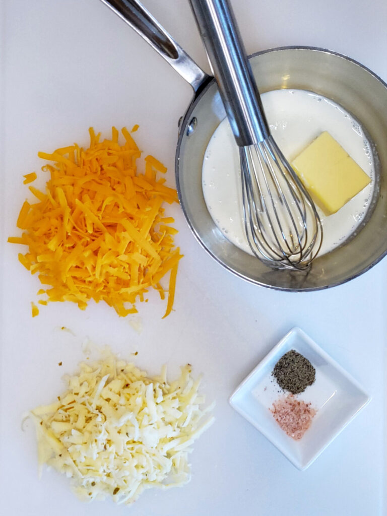 The four ingredients found in this Quick and Easy 5 Minute Queso Dip are portioned out on a cutting board.