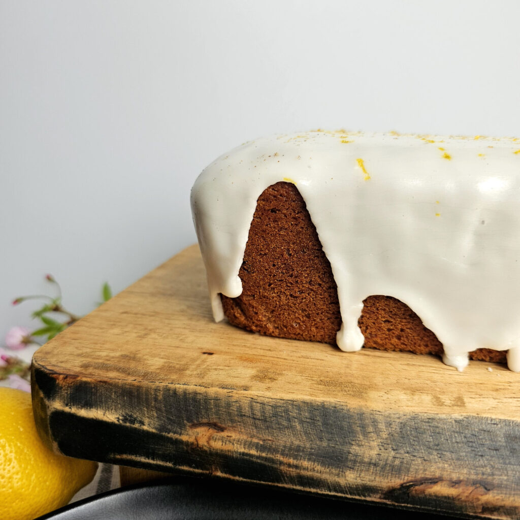 Lemon sugar glaze covers the top of a loaf of this Tempting 2-Step Purple Sweet Potato Quick Bread.