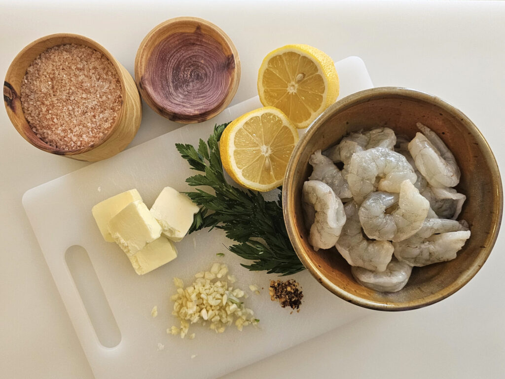 A cutting board features the ingredients used in this Ridiculously Easy Shrimp Scampi in 20 Minutes.