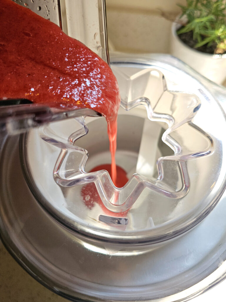 The strawberry puree is poured into an ice cream maker.