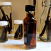A row of freshly prepped bottles of vanilla extract are lined up as the feature image for this recipe on How to Make Homemade Pure Vanilla Extract in 5 Easy Minutes.