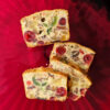Slices of this Festive 5 Star Amaretto Fruitcake are spread out across a tray. The cake is packed with cherries and nuts.