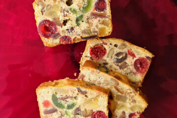 Slices of this Festive 5 Star Amaretto Fruitcake are spread out across a tray. The cake is packed with cherries and nuts.