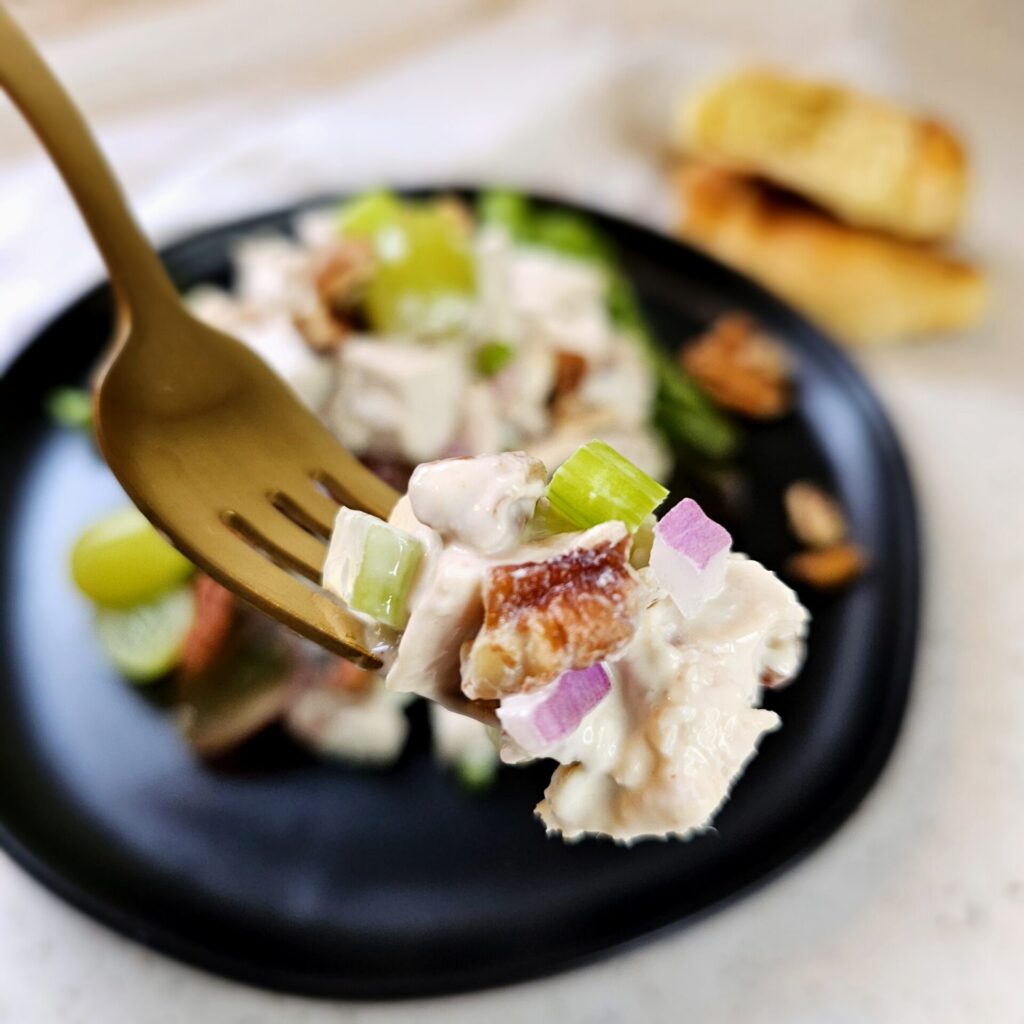 A generous portion of this Easy Classic Chicken Salad in Under 1 Hour sits atop a bed of spring greens.