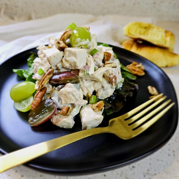 A generous portion of this Easy Classic Chicken Salad in Under 1 Hour sits atop a bed of spring greens.