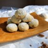 A tray of these Easy Old Fashioned 2-Bite Pecan Sandies sit piled high in a pyramid on a small wooden tray.