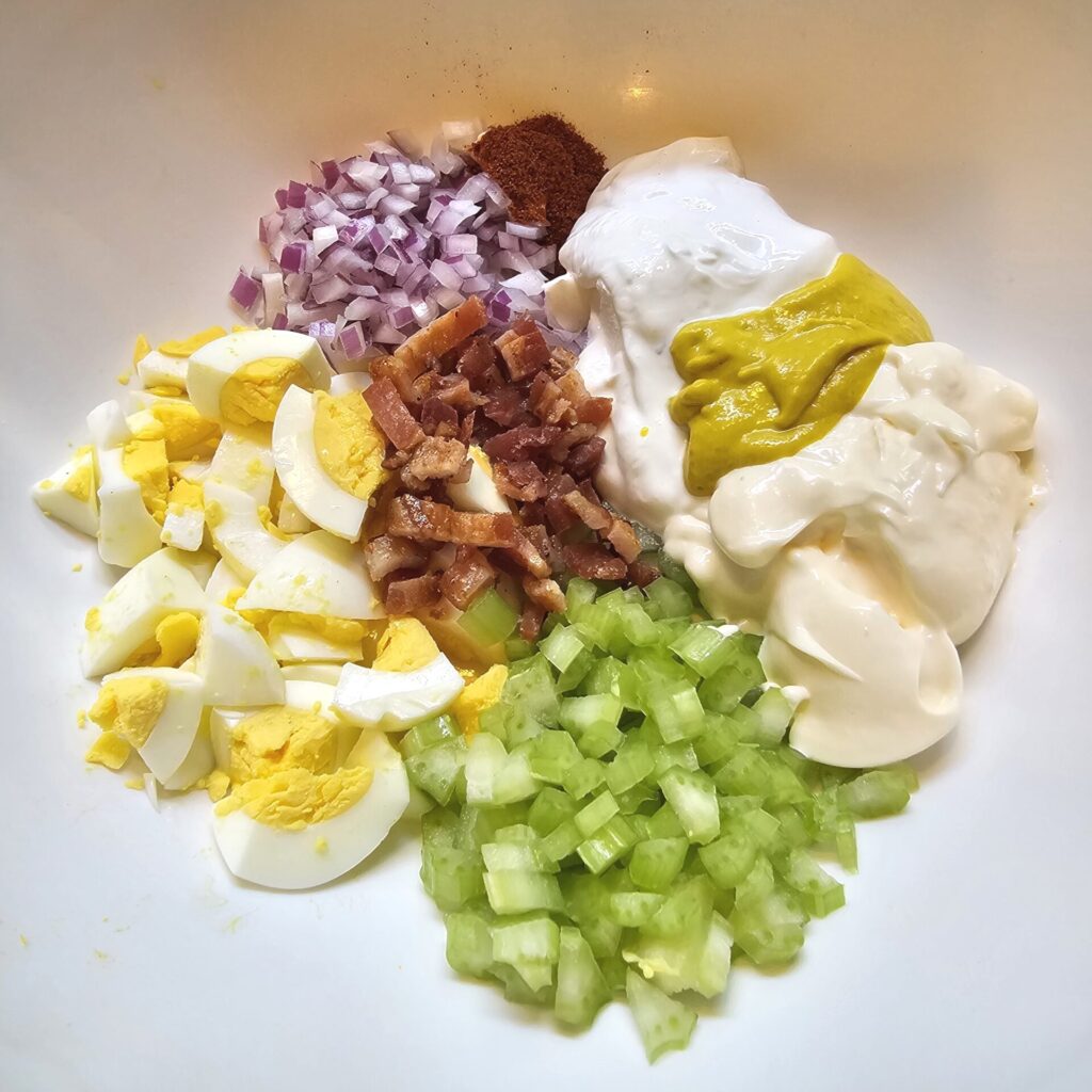 A mixing bowl is prepped with all the ingredients needed to make this Old Fashioned Mustard Potato Salad.