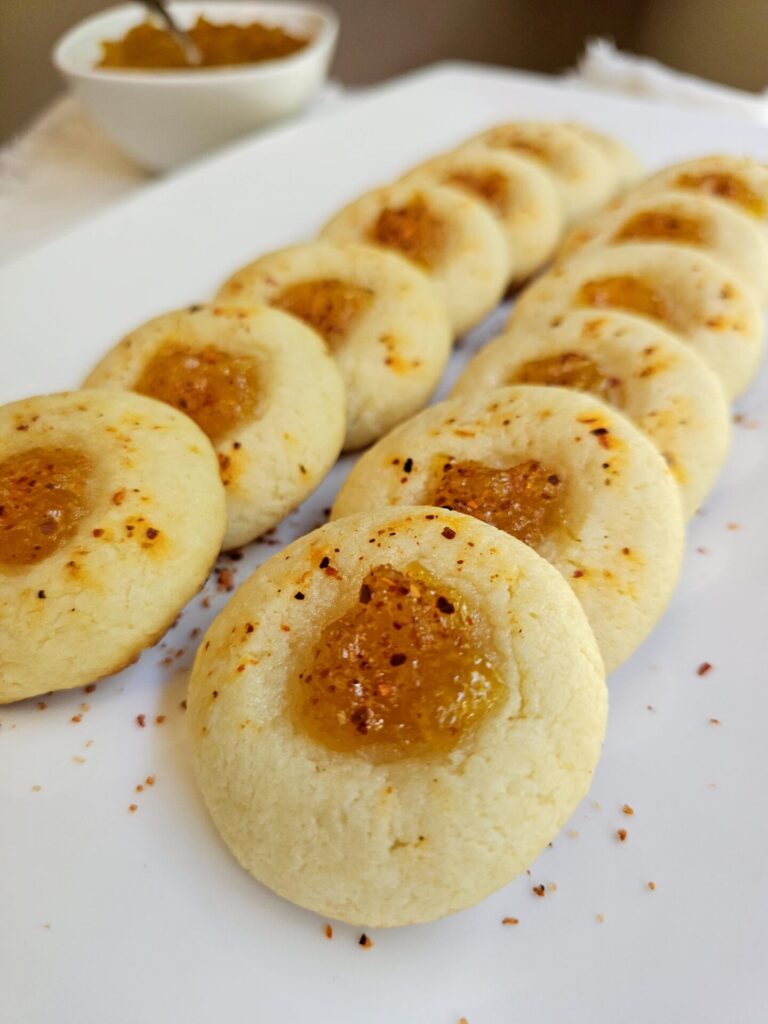 A tray of these Easy 2-Bite Mango Tajín Thumbprints sit in a grouping on a marble board.