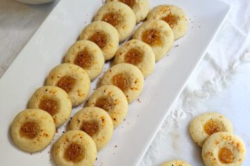A tray of these Easy 2-Bite Mango Tajín Thumbprints sit in a grouping on a marble board.