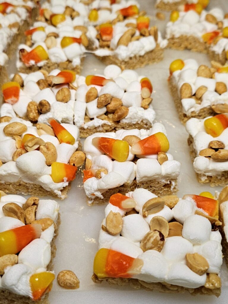 marshmallows, candy corn and peanuts top these fall peanut butter rice krispie bars.