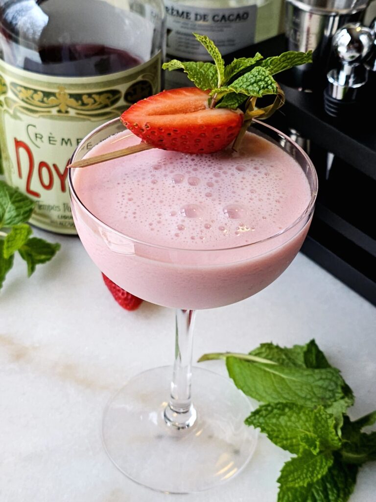 Charming 5 Ingredient Pink Squirrel Cocktail with a strawberry garnish.