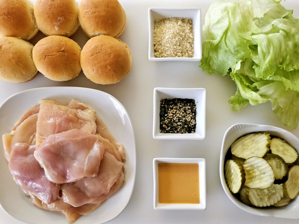 A cutting board displays all the ingredients needed to makes these Yum Yum Furikake Chicken Sliders. 