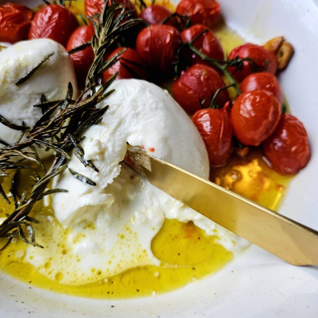 20-Minute Roasted Tomatoes and Burrata Crostini sit on a plate 