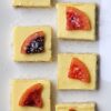 Irresistible 3-Layer Candied Blood Orange Cheesecake Squares are lined up on a serving tray.
