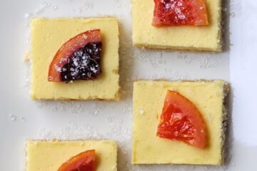 Irresistible 3-Layer Candied Blood Orange Cheesecake Squares are lined up on a serving tray.