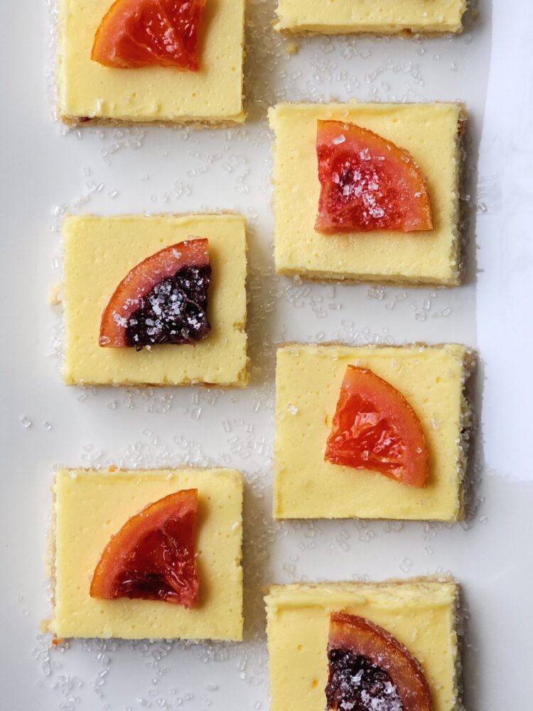 Irresistible 3-Layer Candied Blood Orange Cheesecake Squares are lined up on a serving tray.