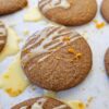 An image of a tray of Easy Vegan Gingersnaps that are finished in a clementine citrus glaze and sprinkled lightly with fresh clementine zest.
