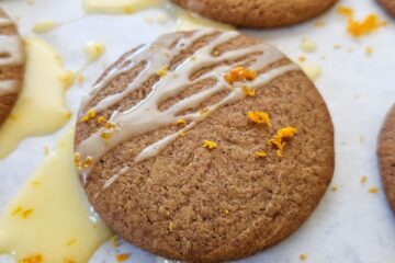 An image of a tray of Easy Vegan Gingersnaps that are finished in a clementine citrus glaze and sprinkled lightly with fresh clementine zest.