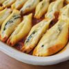 A bubbling hot baking dish of Authentic Italian Stuffed Shells in 1 Hour sits cooling on the kitchen counter.