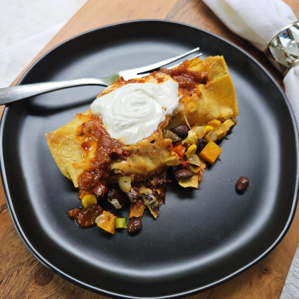 A single serving of these Delicious Vegetarian Enchiladas in 1 Hour sits in the center of a plate.