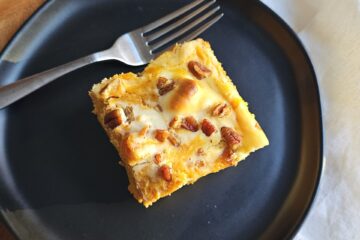 A slice of this easy as 1-2-3 Pumpkin Cheesecake Bread Pudding sits at the center of a plate.