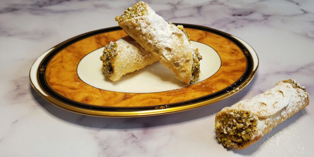 A finished plate of Authentic Sicilian Cannoli Shells - filled with a chocolate and orange cream.