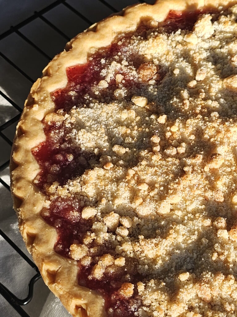 A freshly baked Old Fashioned Tart Cherry Pie is cooling on the counter.
