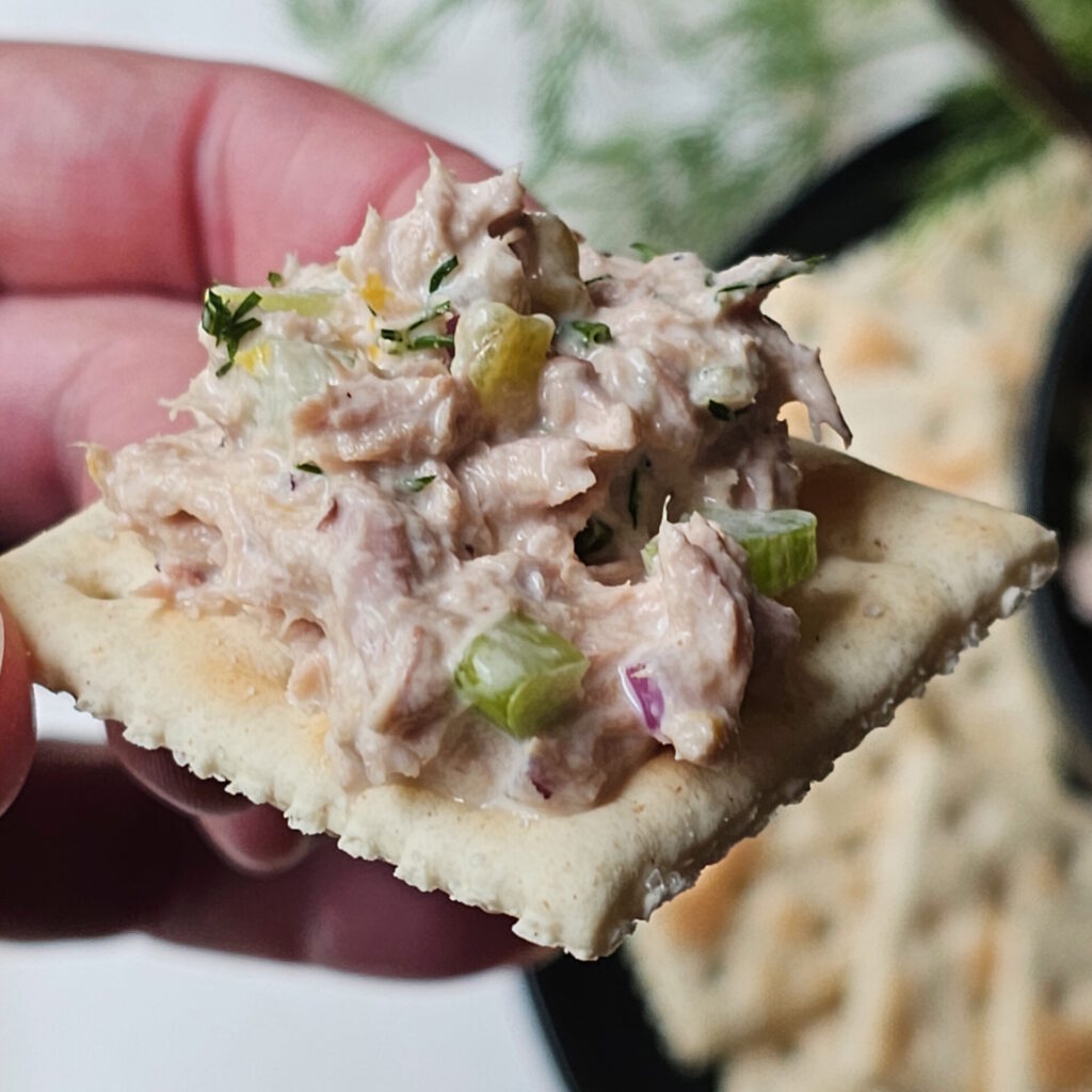 A cracker is piled high with Maria's Homemade Tuna Salad Recipe.